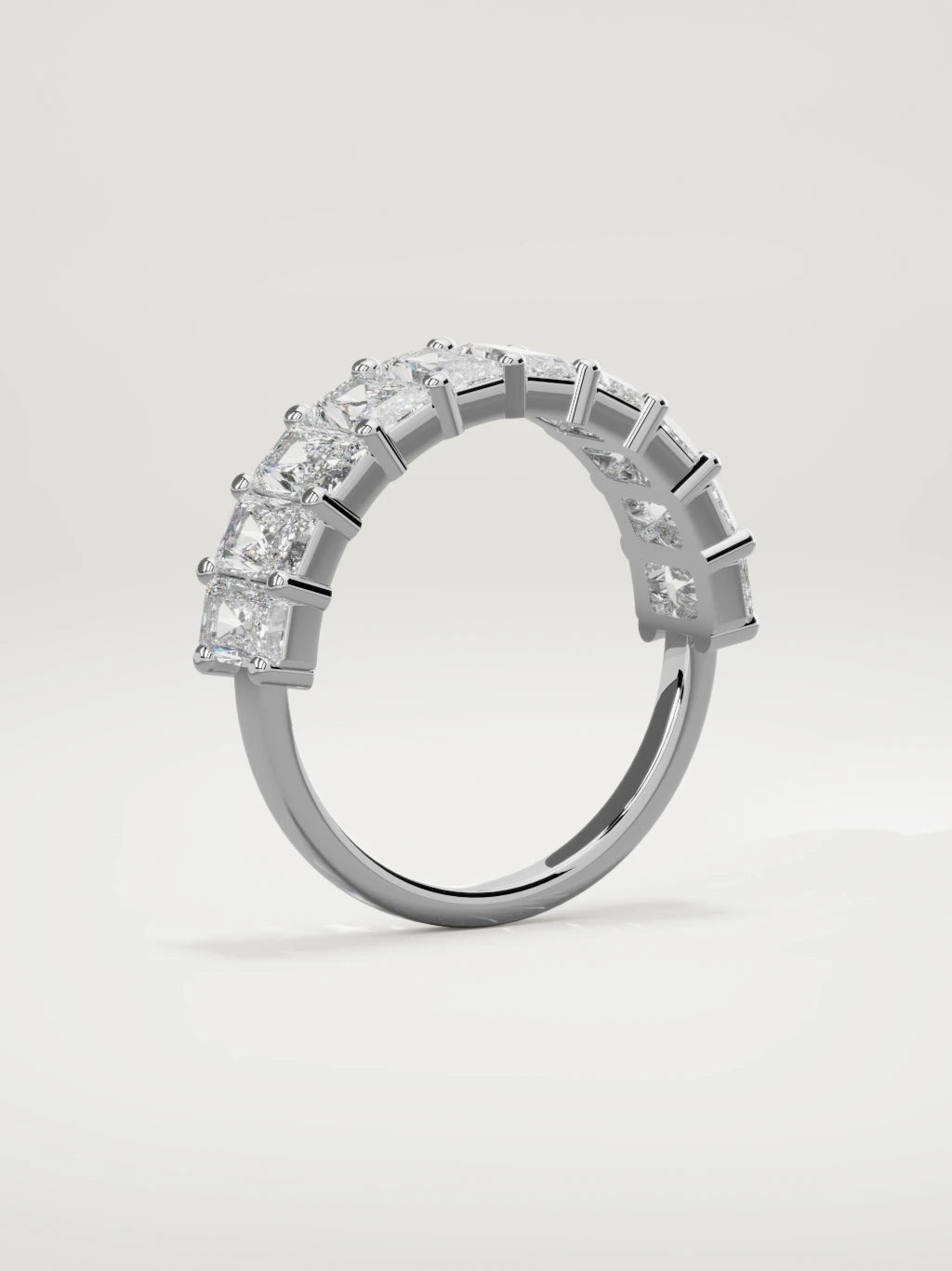The Astra large prong radiant-cut half eternity band in 14K white gold, standing three-quarter view