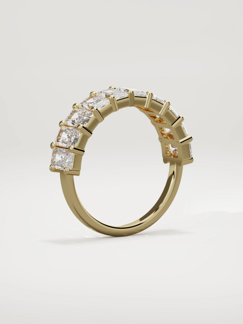 The Astra large prong radiant-cut half eternity band in 14K yellow gold, standing three-quarter view