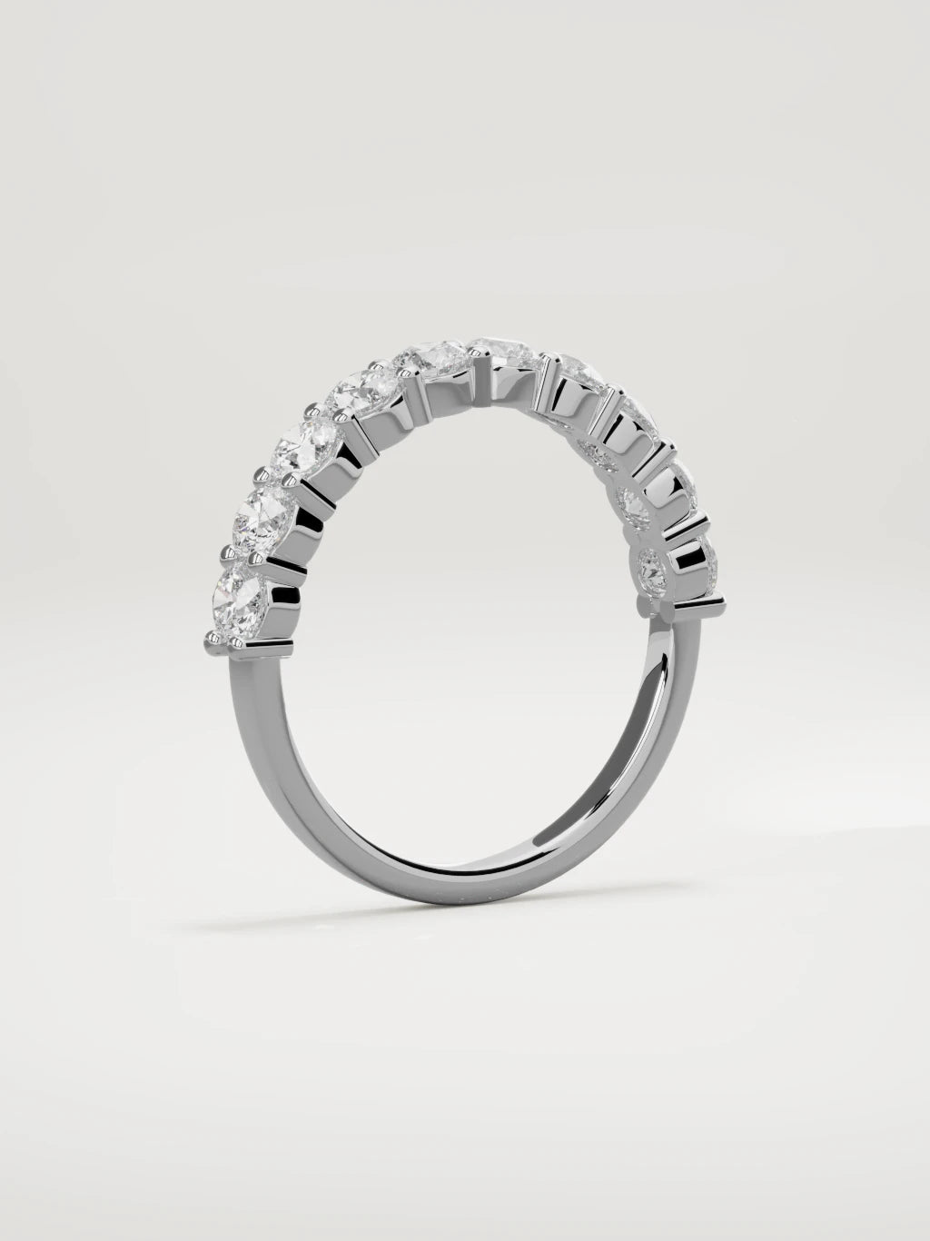 The Clara shared-prong half eternity band in 14K white gold, standing three-quarter view