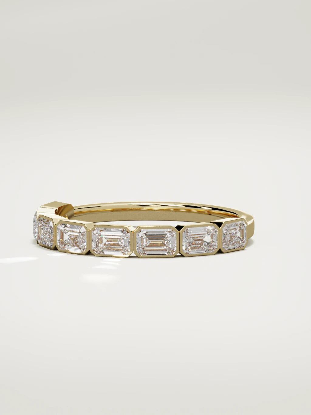 The Cristal east-west bezel emerald-cut band in 14K yellow gold, three-quarter view