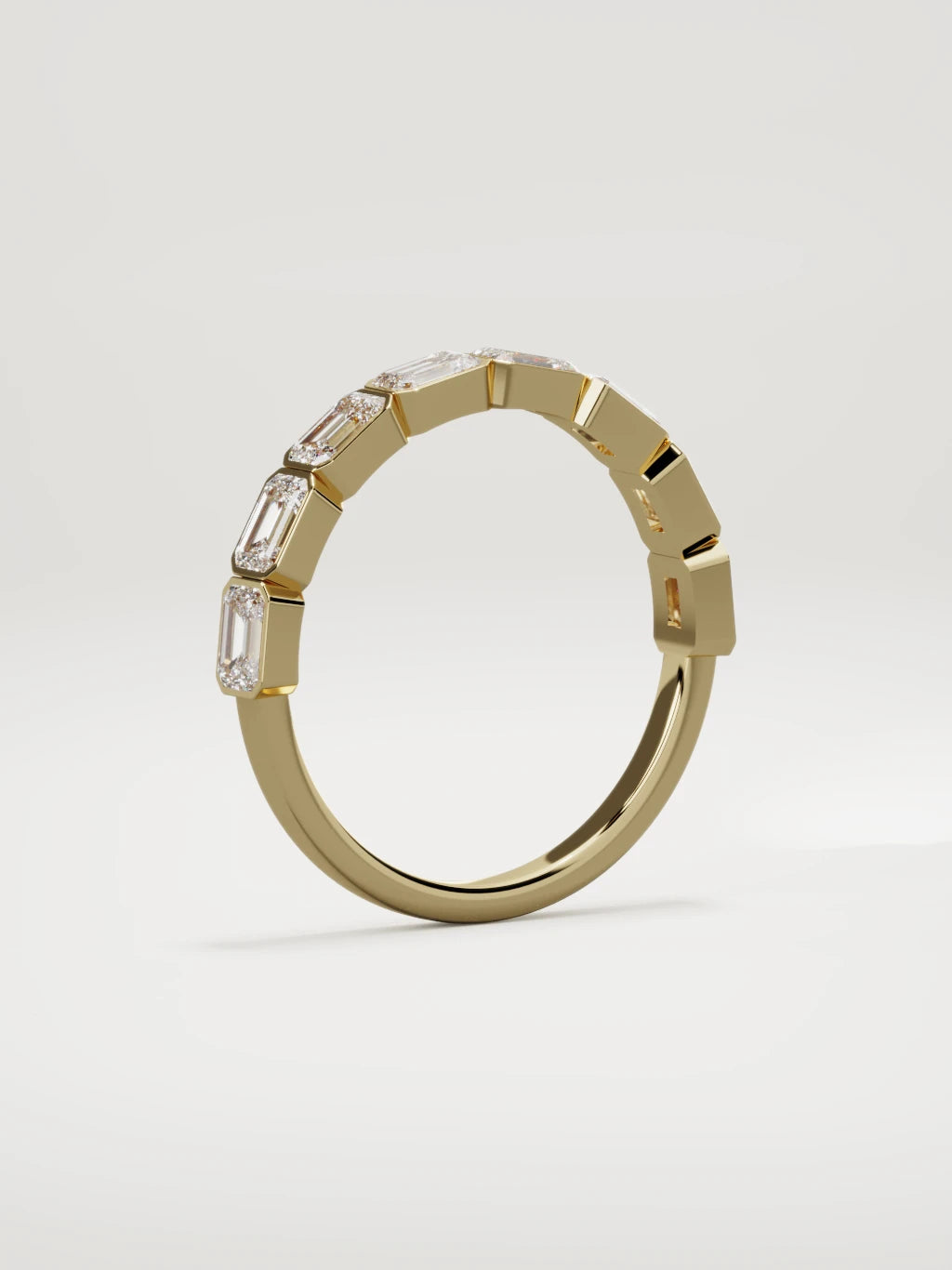 The Cristal east-west bezel emerald-cut band in 14K yellow gold, standing three-quarter view