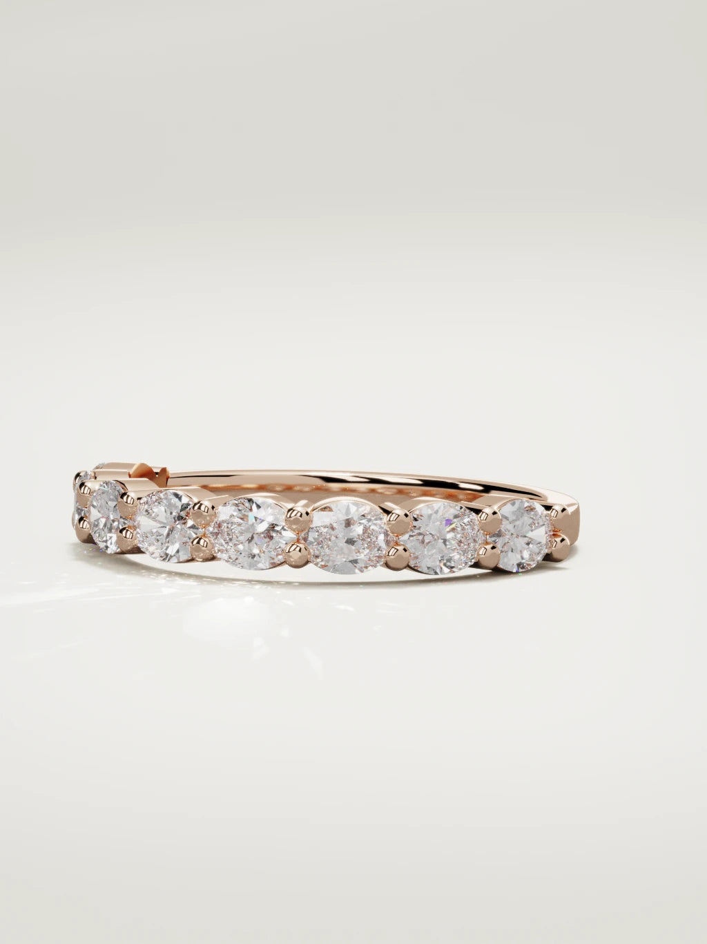The Dama east-west oval half eternity band in 14K rose gold, three-quarter view
