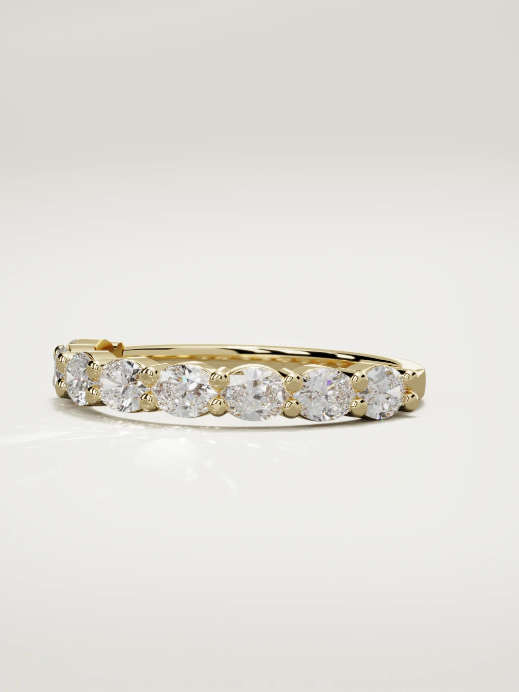 The Dama east-west oval half eternity band in 14K yellow gold, three-quarter view