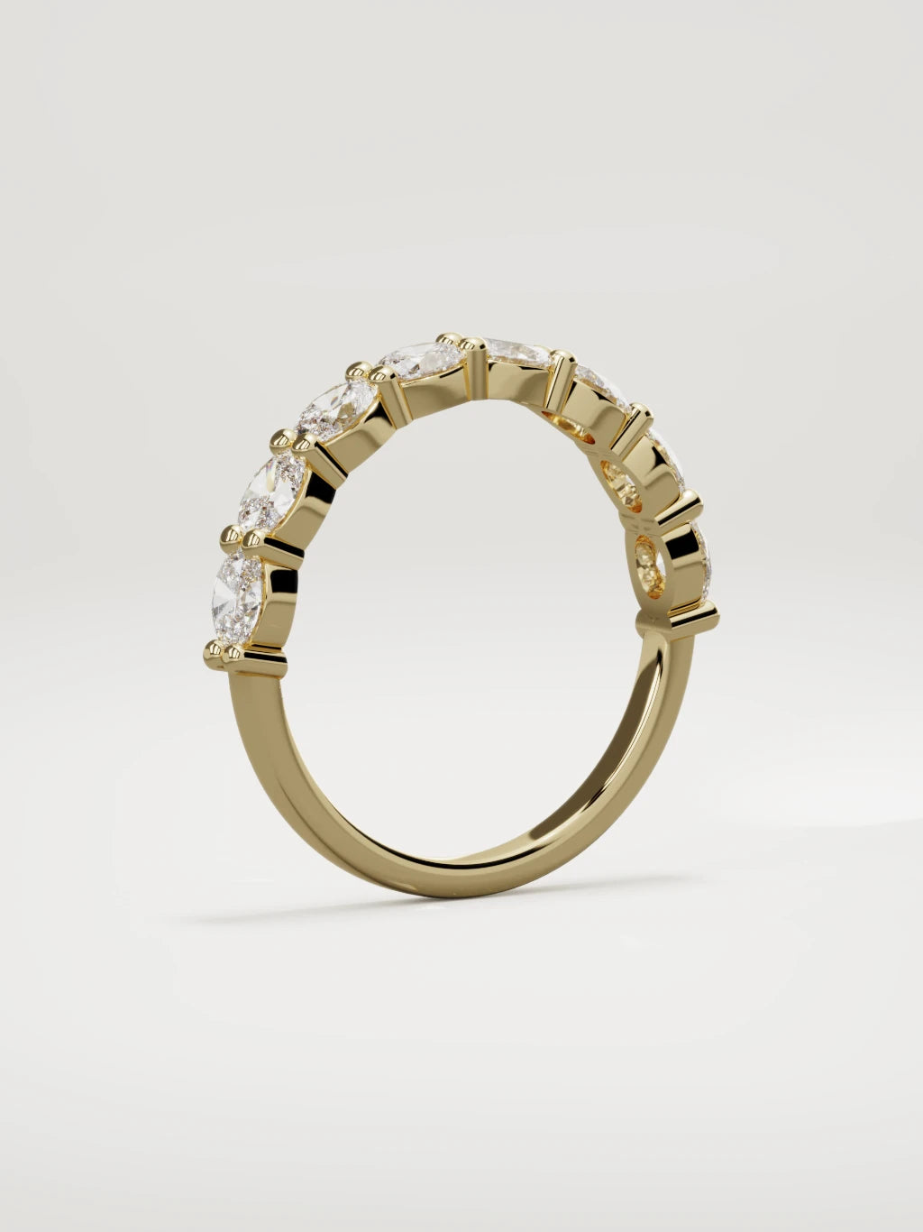 The Dama east-west oval half eternity band in 14K yellow gold, standing three-quarter view