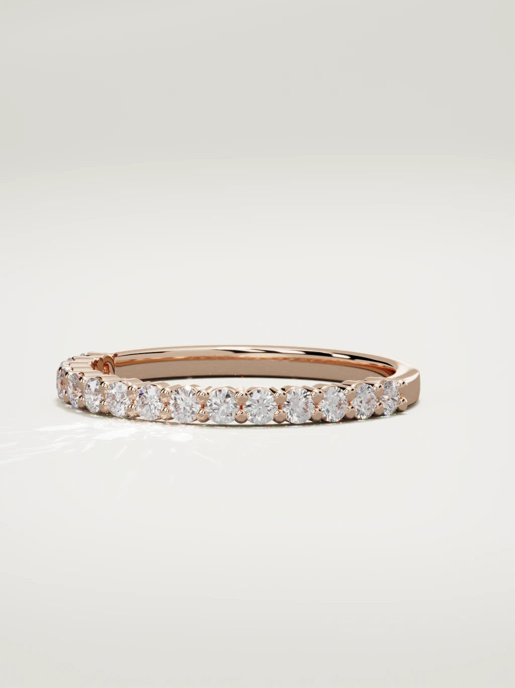 The Danza petite shared-prong half eternity band in 14K rose gold, three-quarter view