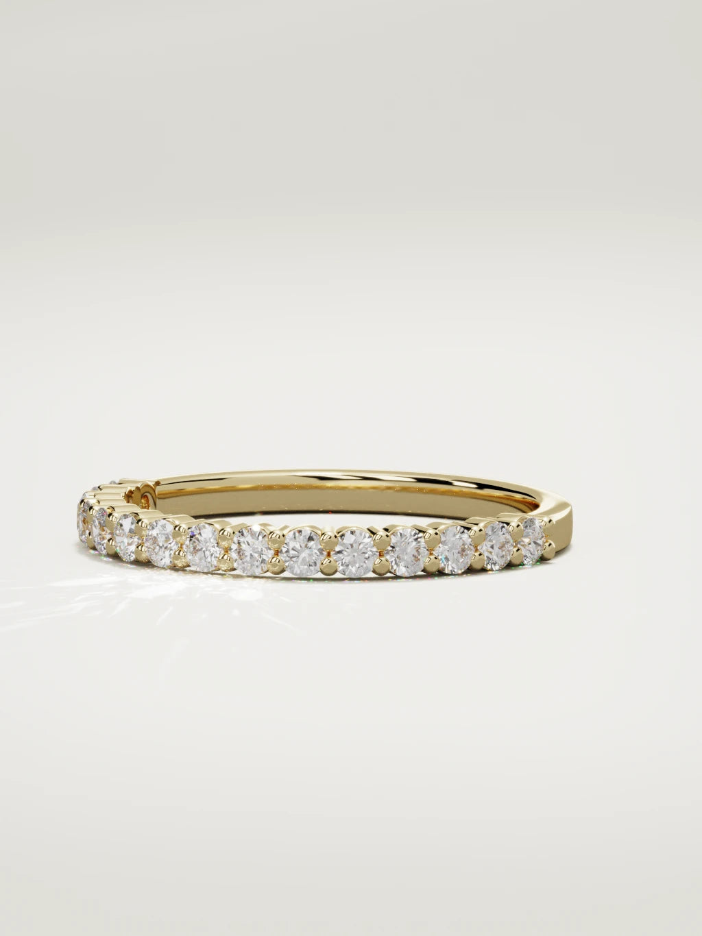 The Danza petite shared-prong half eternity band in 14K yellow gold, three-quarter view