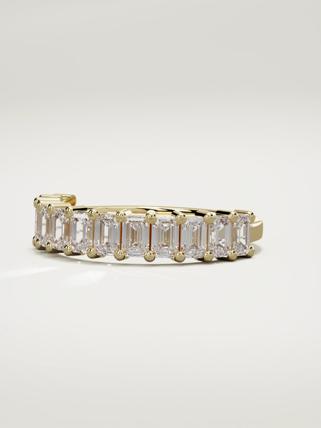 The Gracia prong emerald-cut half eternity band in 14K yellow gold, three-quarter view