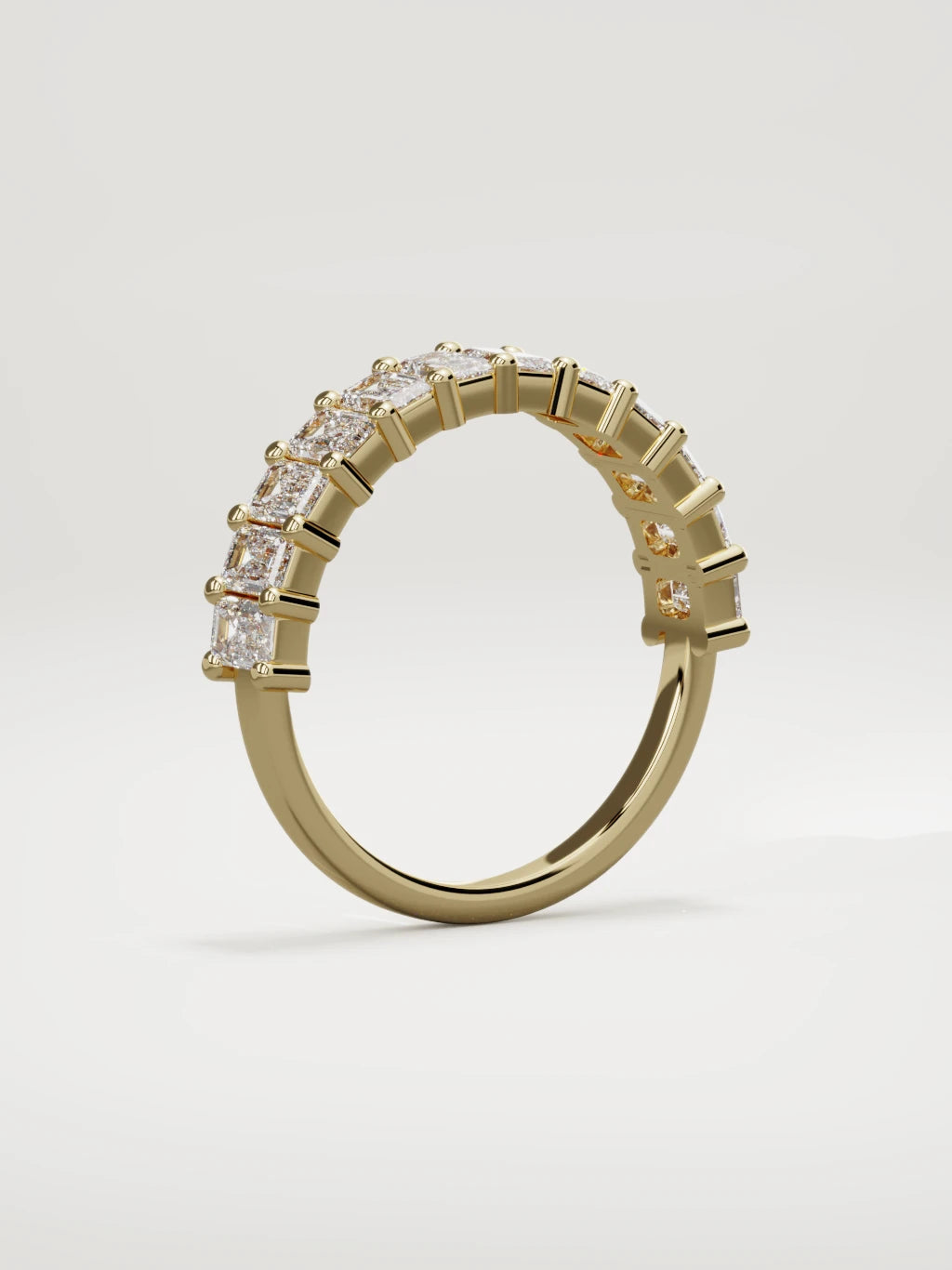 The Gracia prong emerald-cut half eternity band in 14K yellow gold, standing three-quarter view