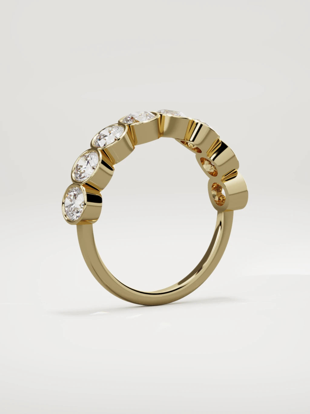 The Lumen large bezel bubble half eternity band in 14K yellow gold, standing three-quarter view