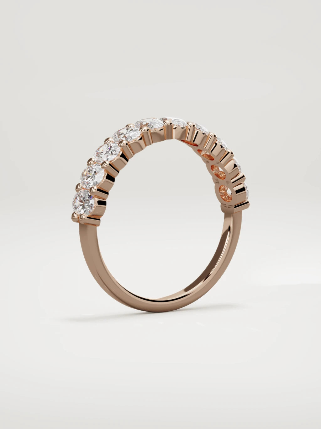 The Musa north-south oval half eternity band in 14K rose gold, standing three-quarter view