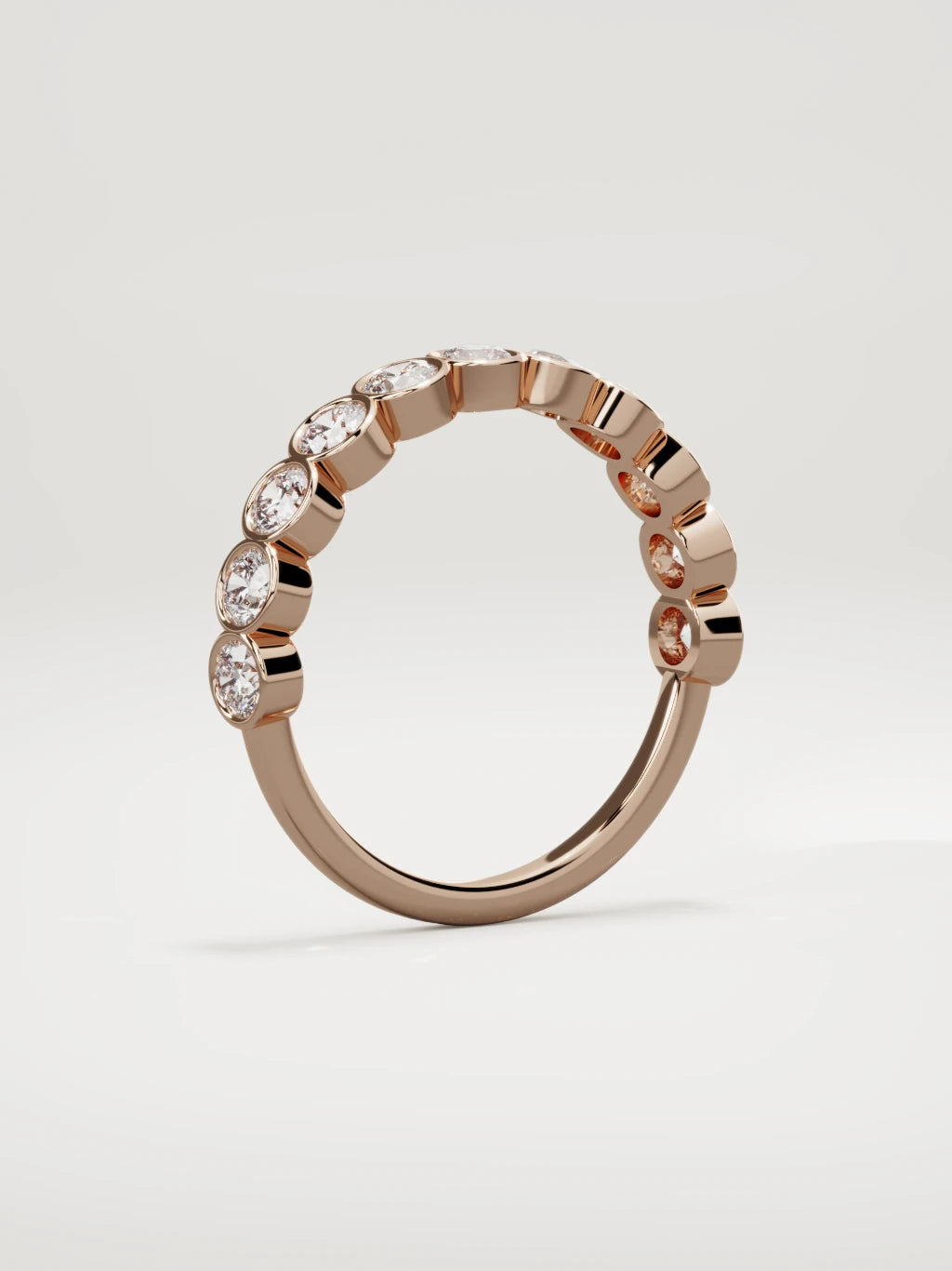 The Perla bezel bubble half eternity band in 14K rose gold, standing three-quarter view