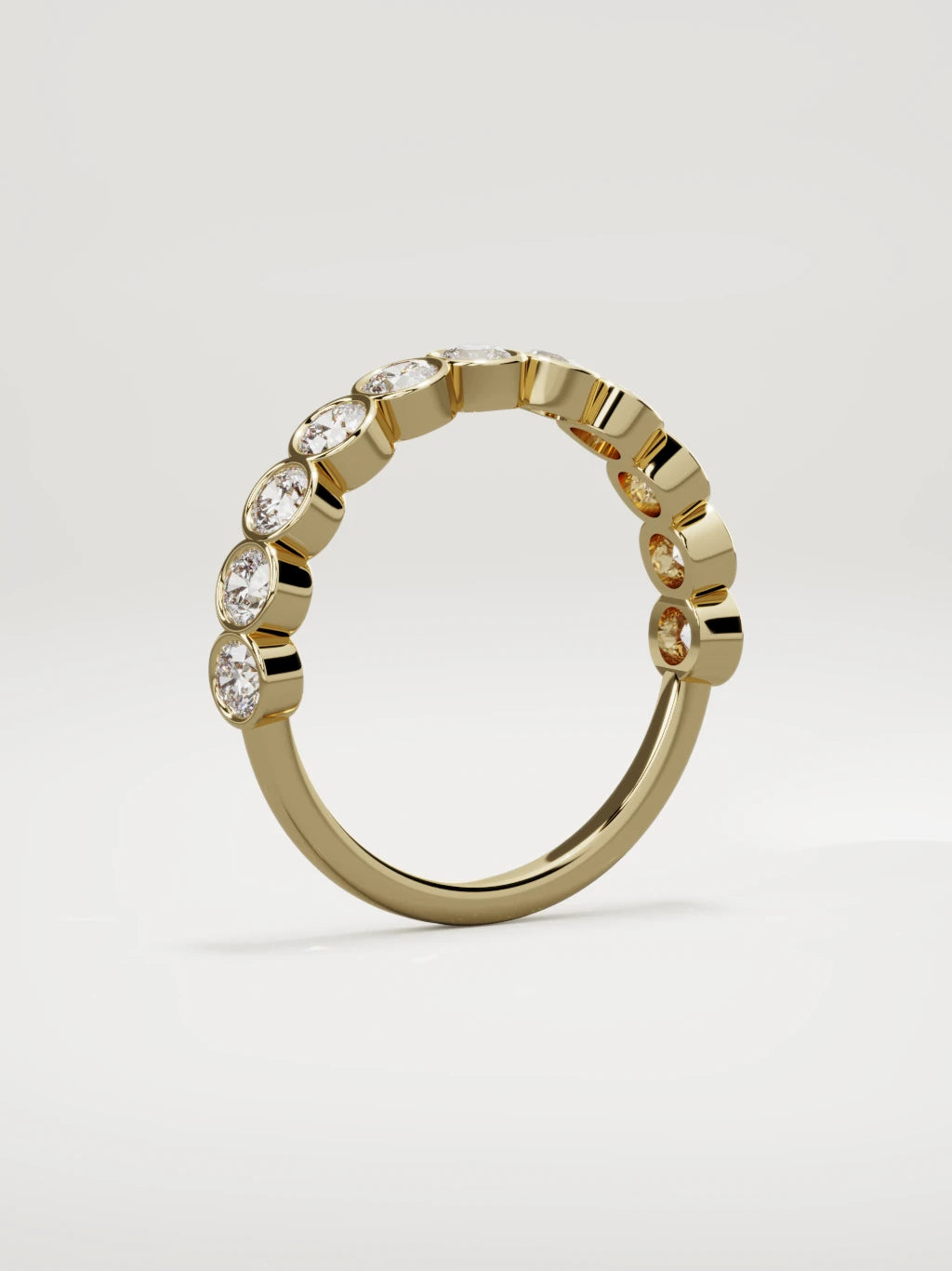 The Perla bezel bubble half eternity band in 14K yellow gold, standing three-quarter view