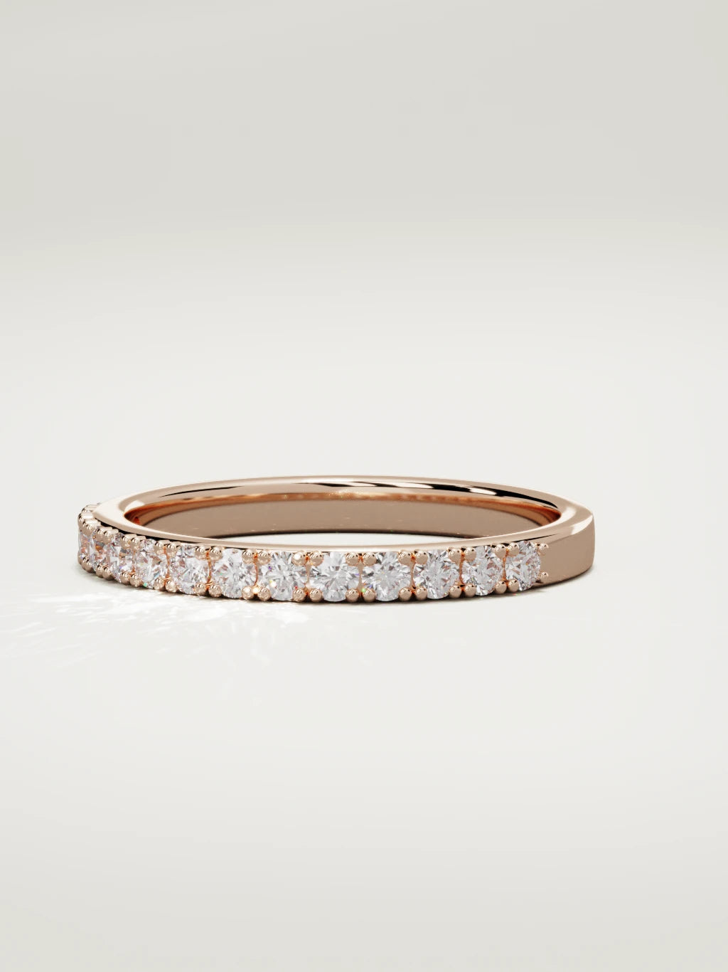 The Sutil low-profile petite half eternity band in 14K rose gold, three-quarter view