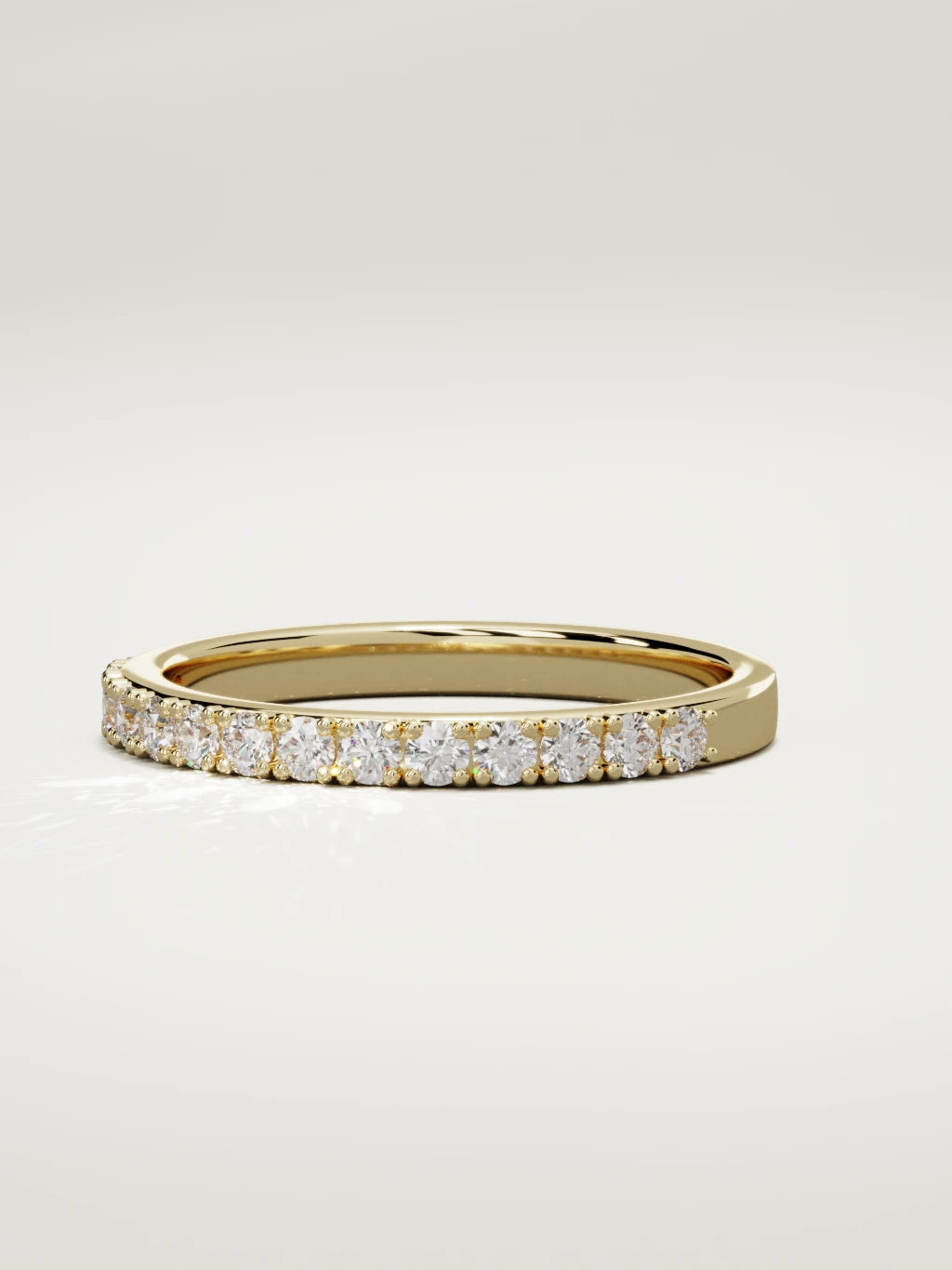 The Sutil low-profile petite half eternity band in 14K yellow gold, three-quarter view