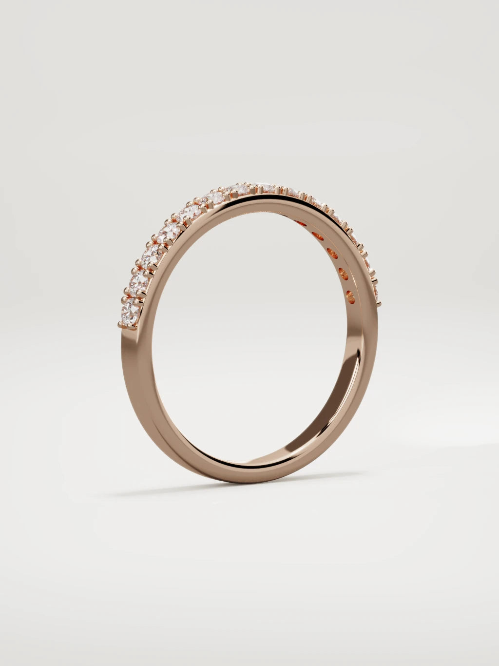 The Sutil low-profile petite half eternity band in 14K rose gold, standing three-quarter view