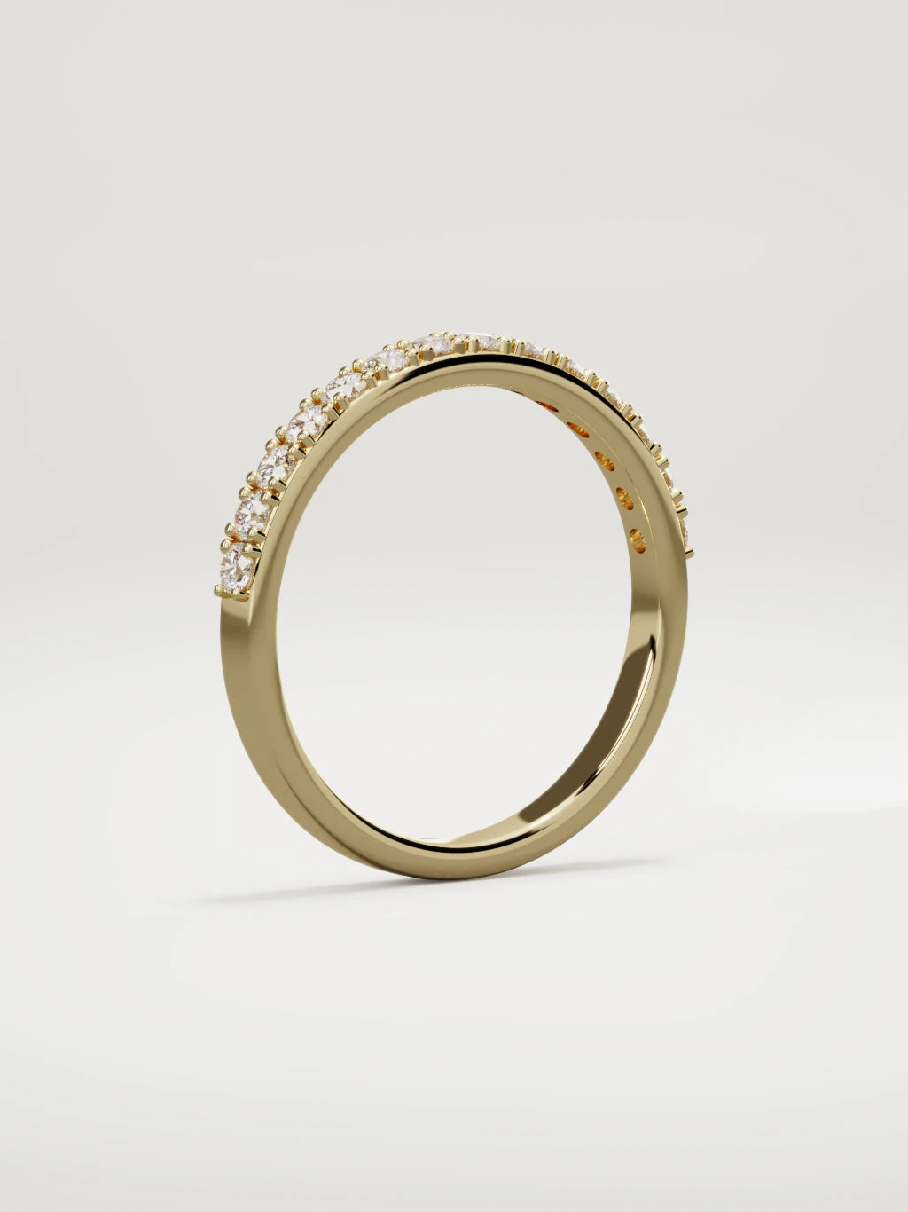 The Sutil low-profile petite half eternity band in 14K yellow gold, standing three-quarter view