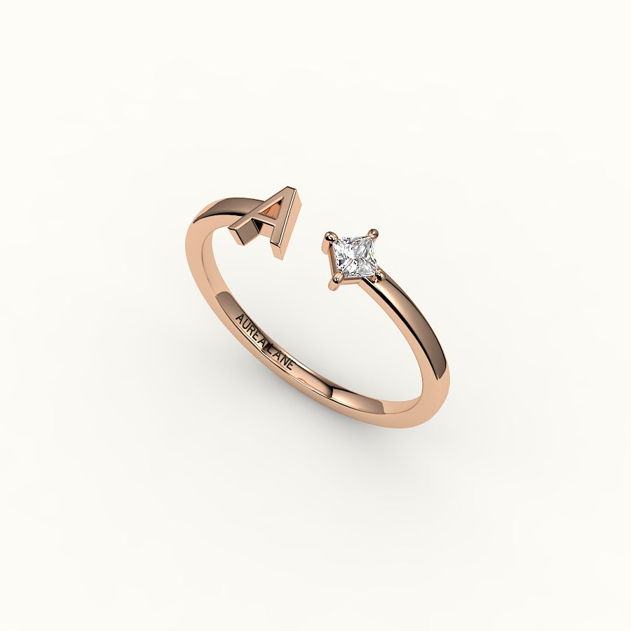 Anillo de diamantes y inicial de corte princesa con brújula