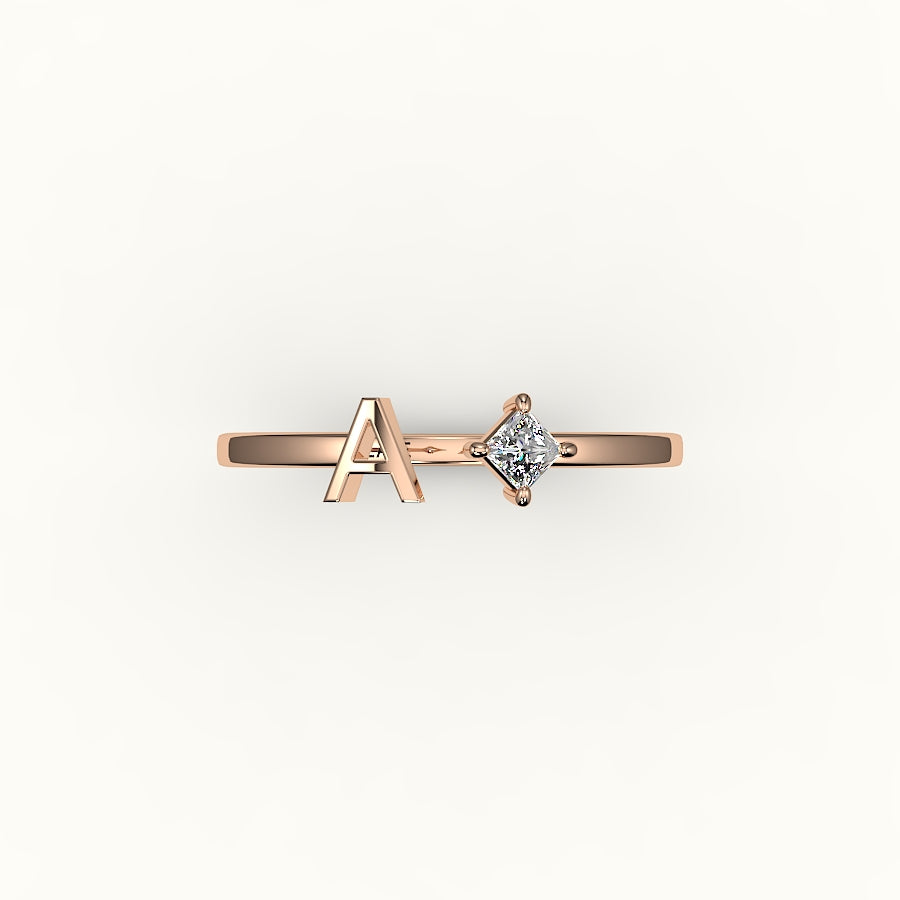 Anillo de diamantes y inicial de corte princesa con brújula