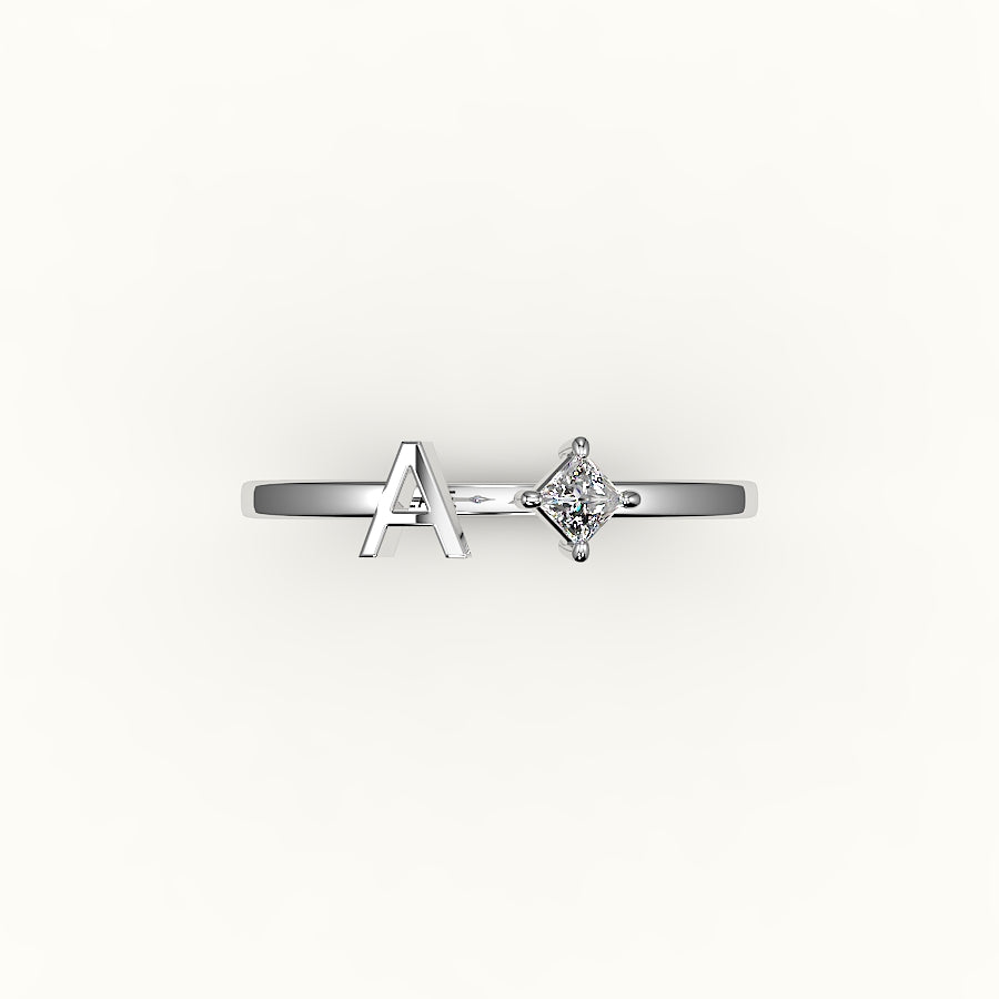 Anillo de diamantes y inicial de corte princesa con brújula