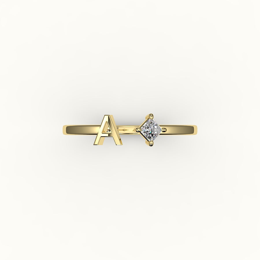 Anillo de diamantes y inicial de corte princesa con brújula